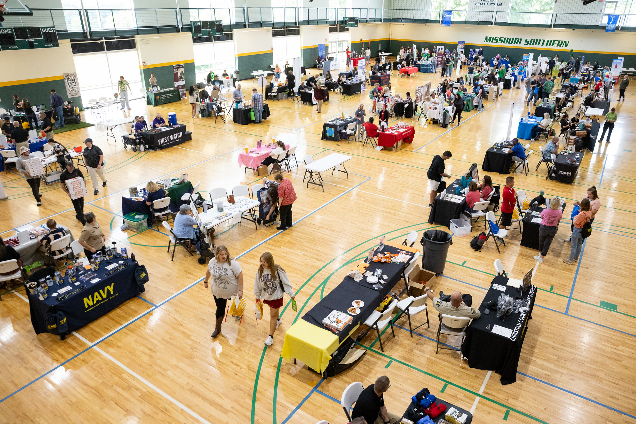 booths setup in a gym with people 