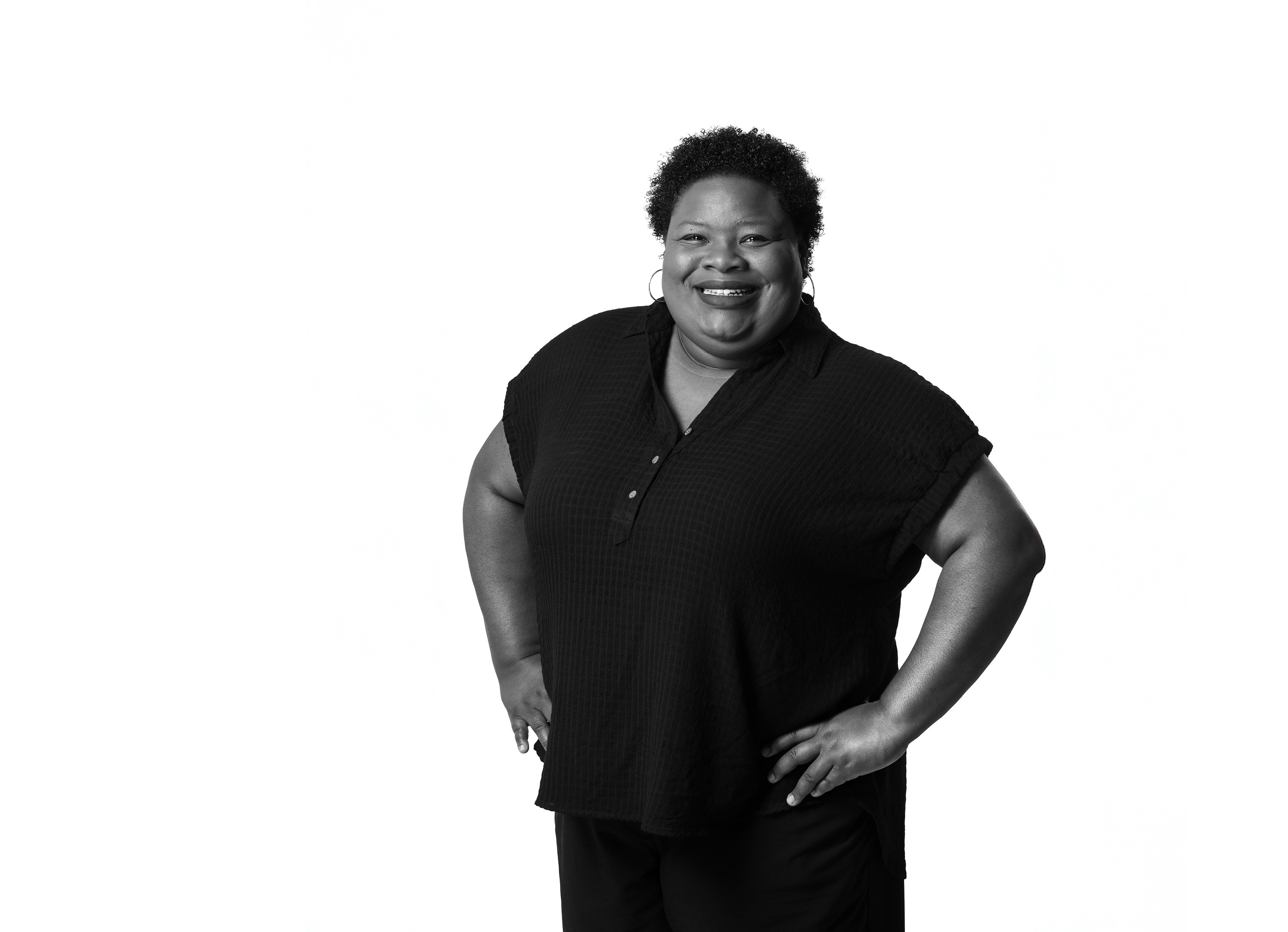 student in a studio smiling with her hands on her hips 