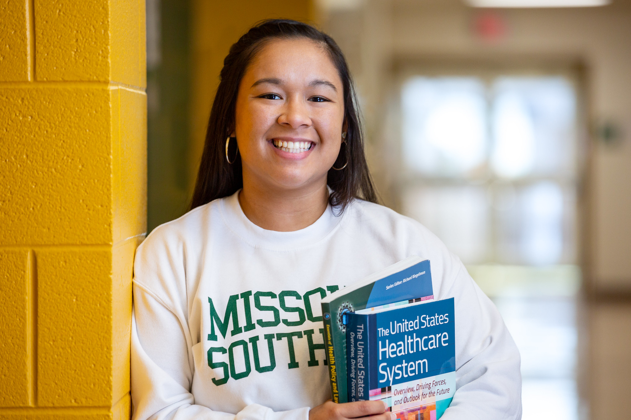 student holding textbook 