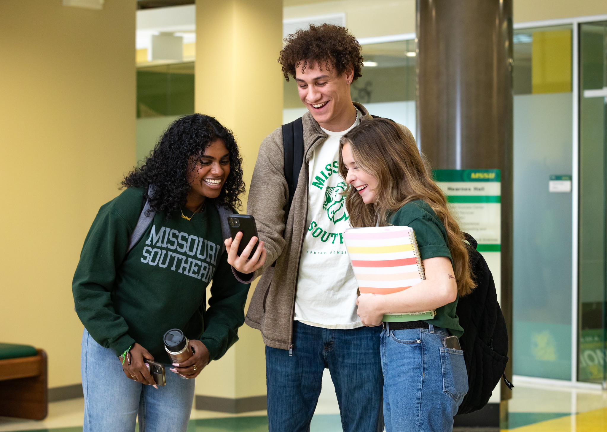 students standing together looking at a phone