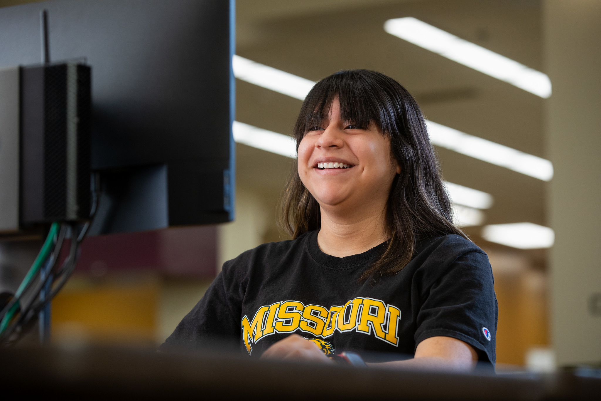 Student smiling and looking at computer 
