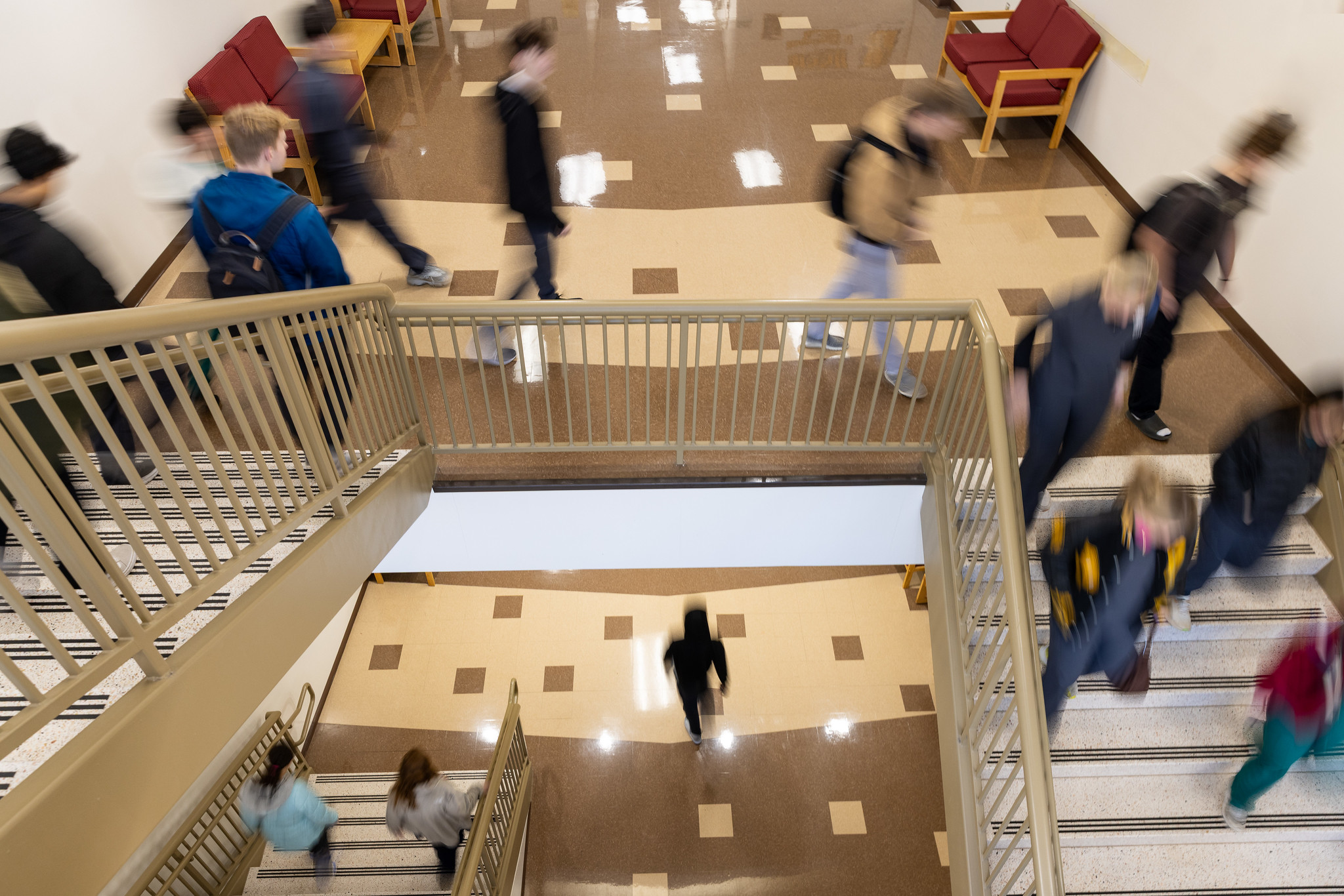blurred photo of students walking down a staircase